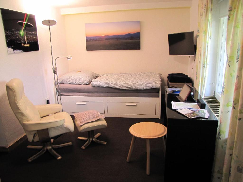 卡塞爾的住宿－Apartment "Hugo37" am Bergpark，小房间设有一张床和一张桌子及椅子
