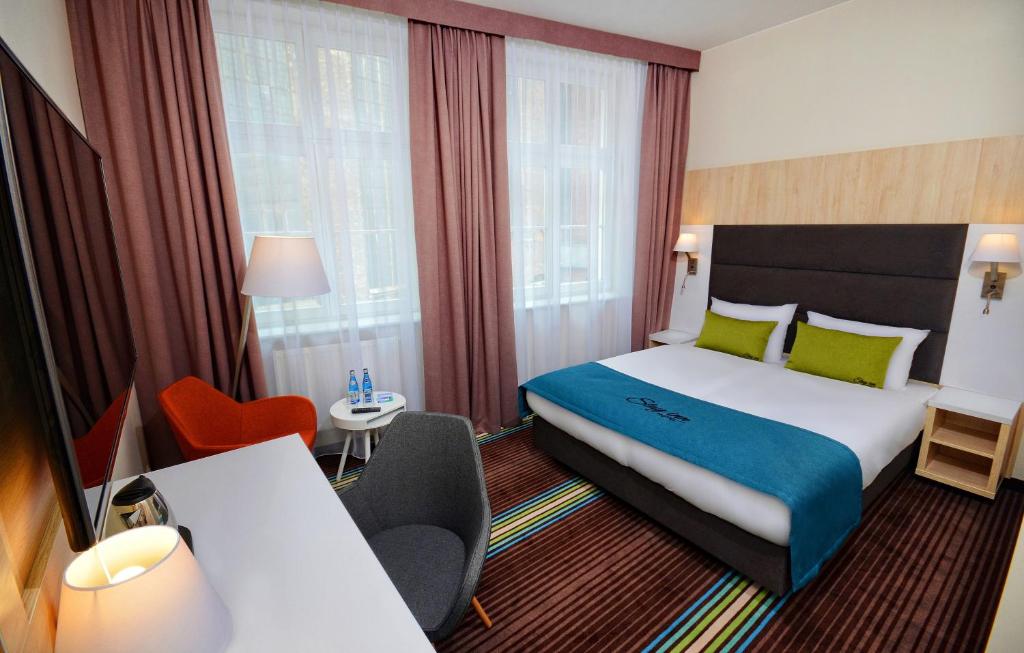 a hotel room with a bed and a table and chairs at Stay inn Hotel Gdańsk in Gdańsk