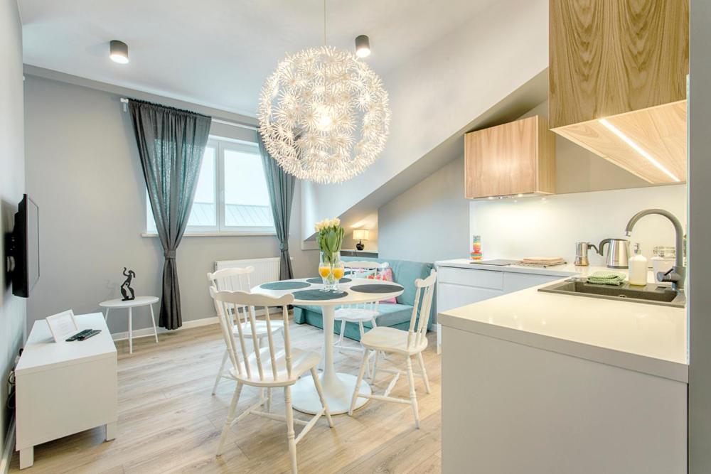 a kitchen and dining room with a table and chairs at Tyzenhauz Apartments Arianska Street in Krakow