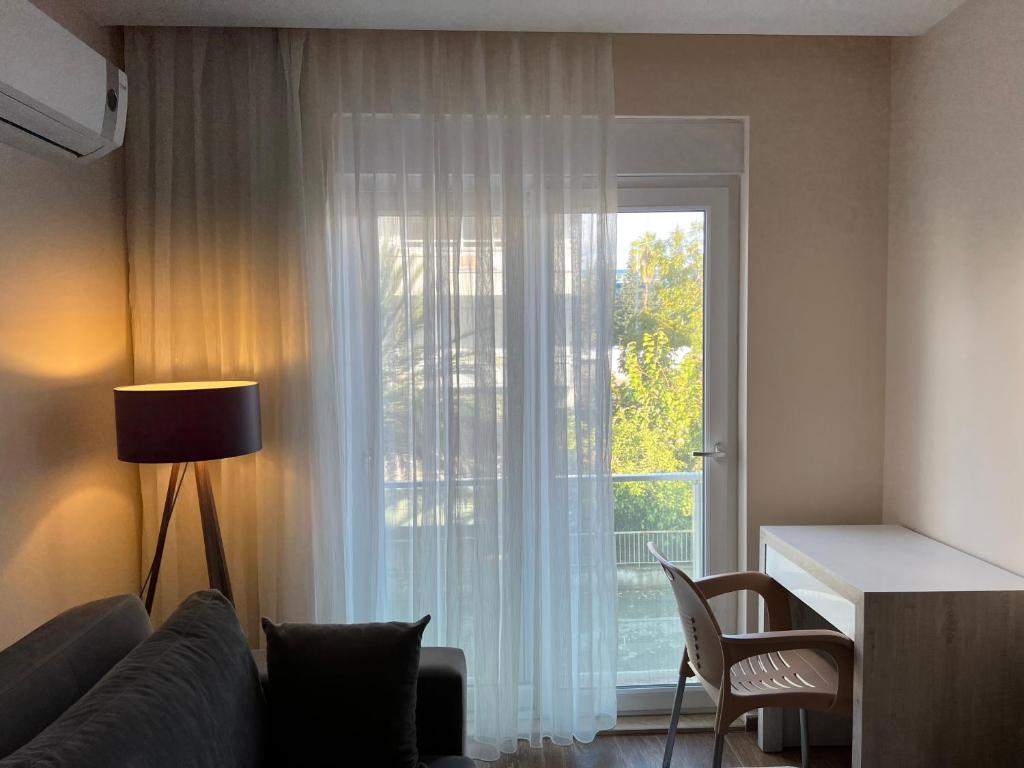 uma sala de estar com um sofá e uma grande janela em Spacious Flat Close To Sea'4' em Antalya