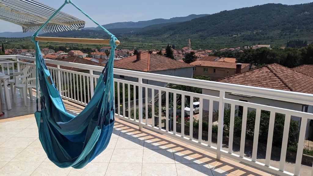 eine Hängematte auf einem Balkon mit Stadtblick in der Unterkunft Apartments Marinko in Stari Grad