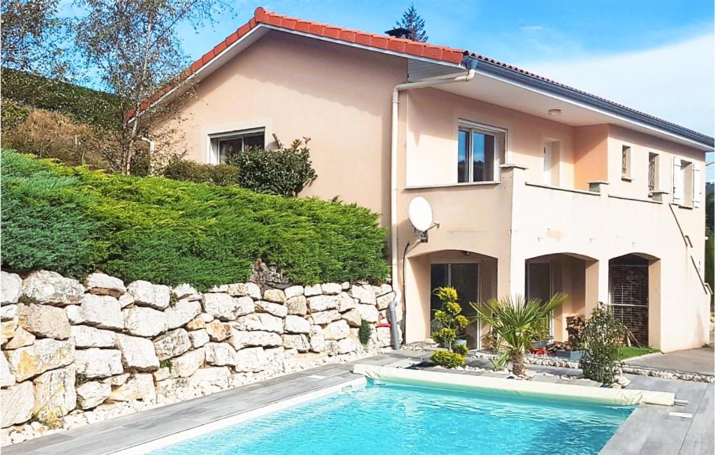 une maison avec piscine à côté d'un mur de pierre dans l'établissement Lovely Home In La Valla En Gier, à La Valla-en Gier