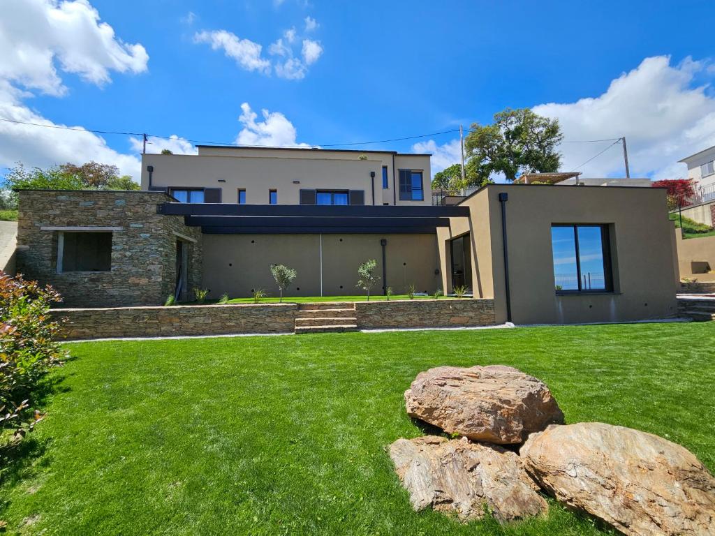 une maison avec quelques pierres dans la cour dans l'établissement Appartement prestige avc piscine - Village Furiani, à Furiani