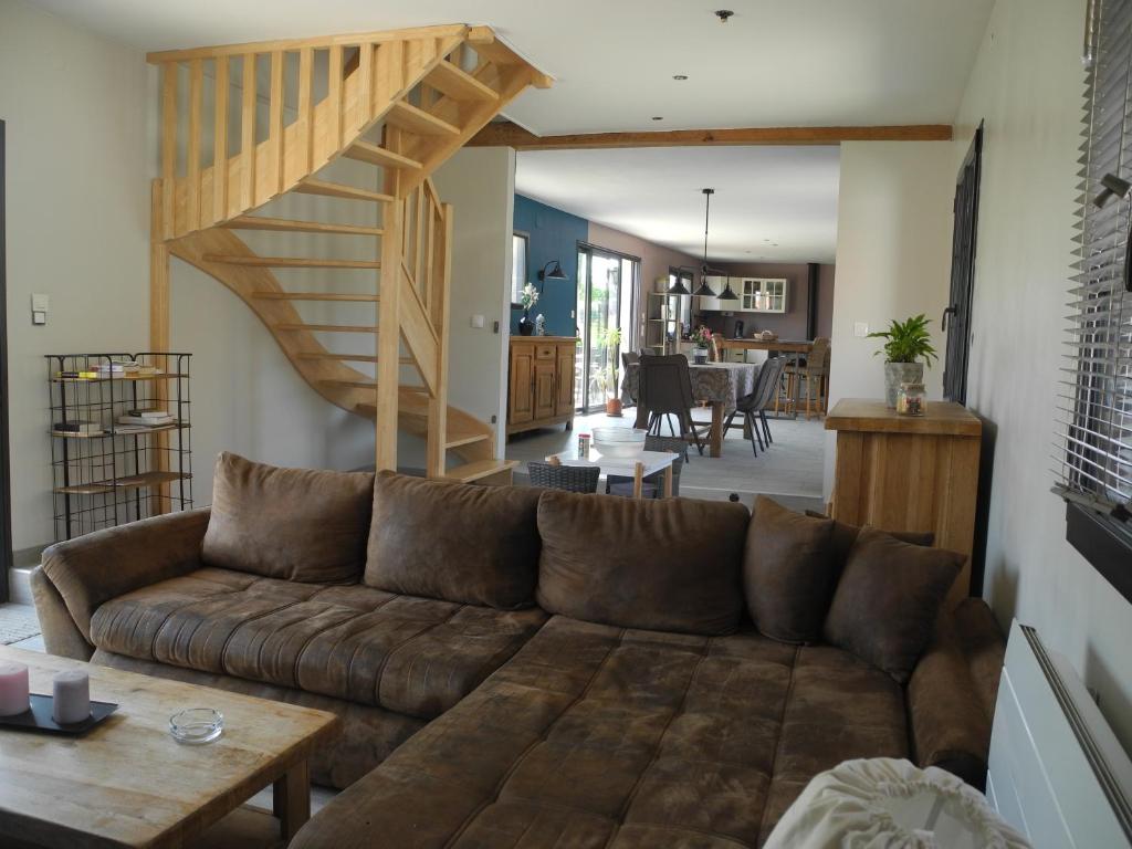 - un salon avec un canapé brun et un escalier dans l'établissement Colline de widehem, à Widehem