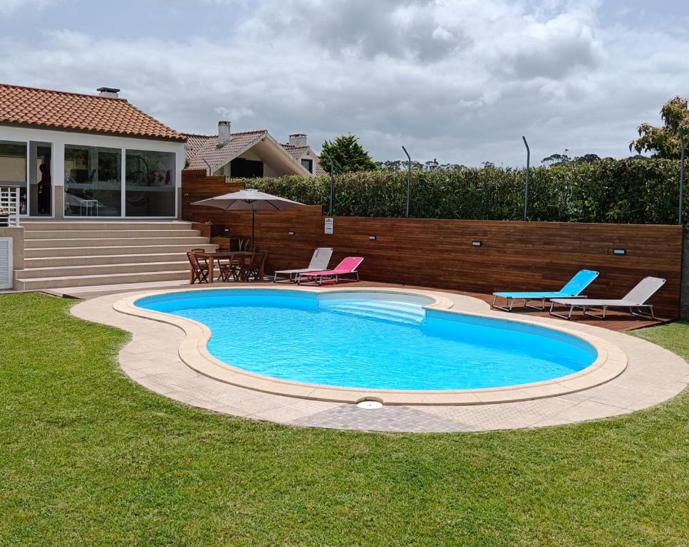 einen Pool im Garten mit Stühlen und einem Tisch in der Unterkunft CASA XAVIER - PISCINA 2735/AL in Ponta Delgada