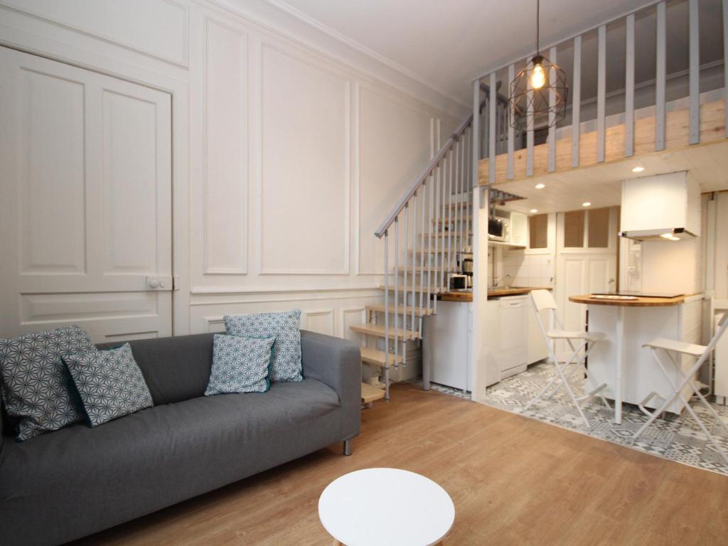 Il comprend un salon avec un canapé gris et une cuisine. dans l'établissement CENTRE MONT-DORE - BEL APPARTEMENT T2 + MEZZANINE - FR-1-608-149, à Le Mont-Dore