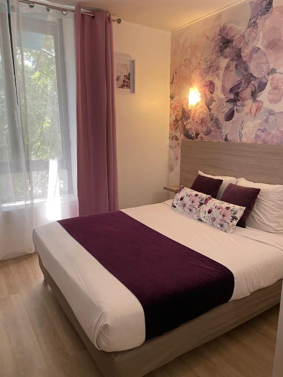 une chambre avec un grand lit avec une grande fenêtre dans l'établissement Empire Hôtel, à Nîmes