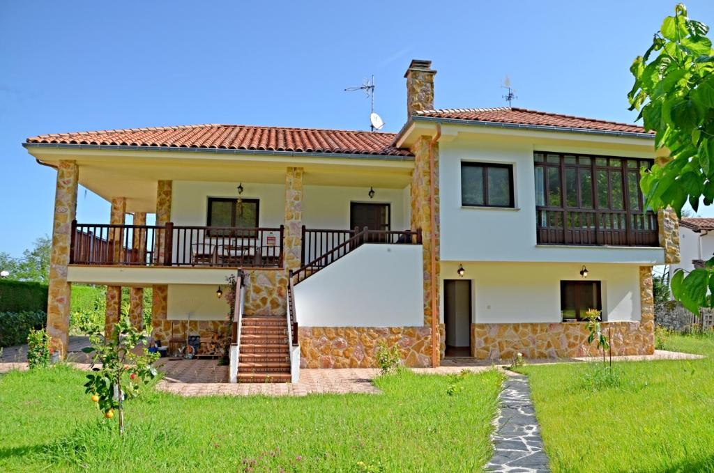 a house with a balcony and a yard at Villa La Atalaya in Llanes