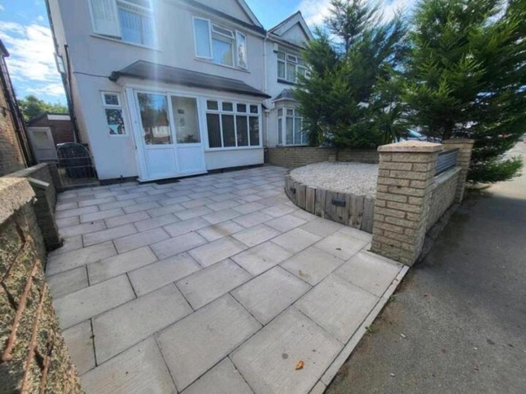 a large white house with a stone patio at Impeccable 2-Bed Apartment in Birmingham in Birmingham