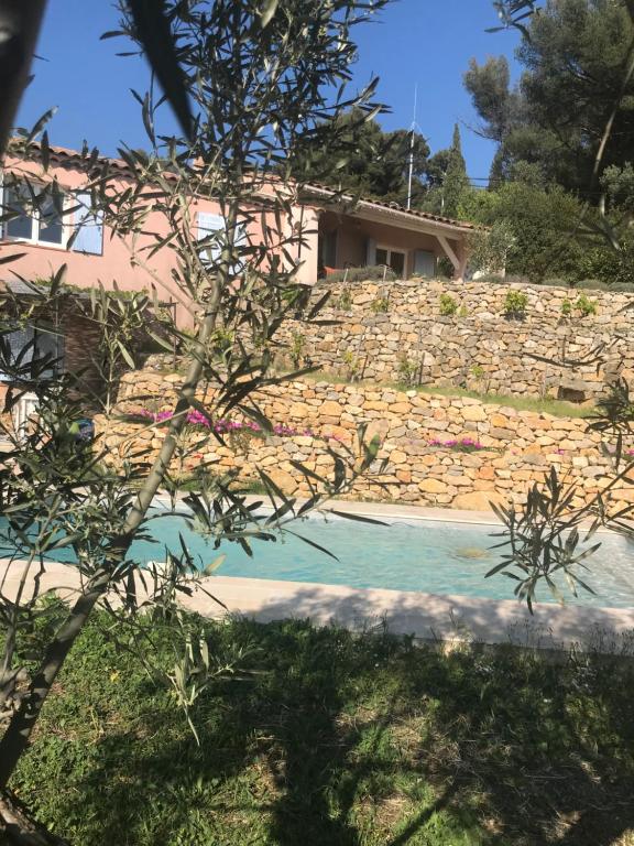 una casa con una pared de piedra y una piscina en Hauteurs de Toulon : Charmant studio piscine en Toulon