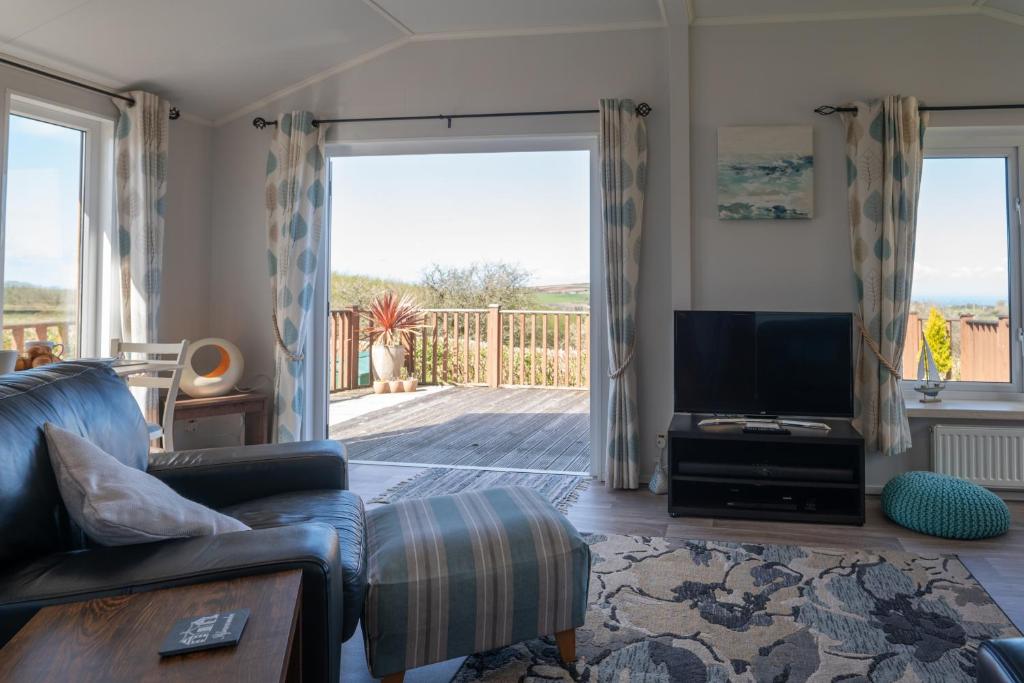a living room with a couch and a television at 4 Meadow View in Woolacombe