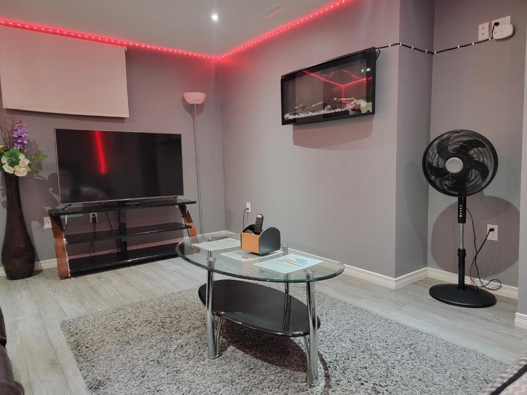 a living room with a tv and a glass table at Staycation Apartment, Free Parking ,kitchen & washroom ensuite in London