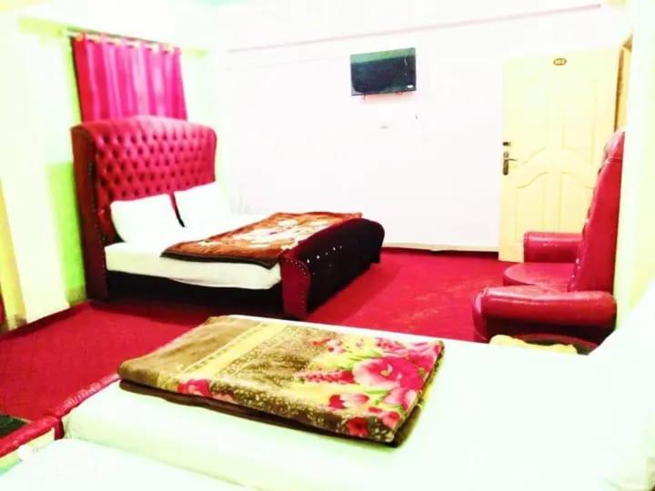 Kashmir premium hotel في Narul: غرفة معيشة مع سرير وأريكة وكراسي