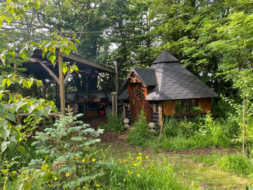 a small house in the middle of a garden at The Hobbit House and Secret Garden in Taunton