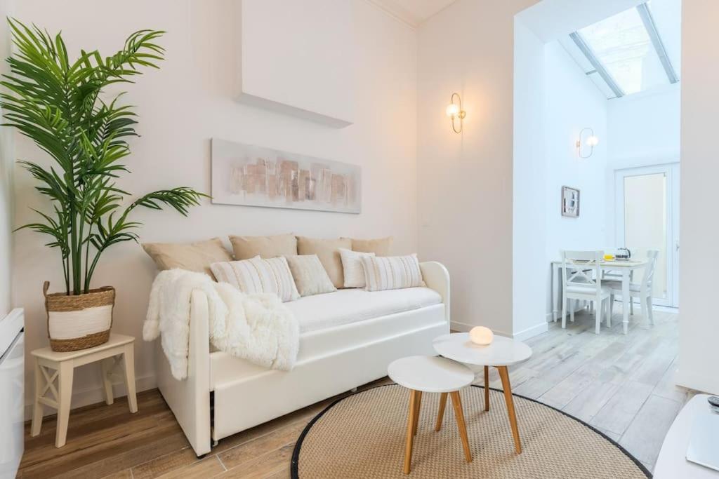 ein weißes Wohnzimmer mit einer weißen Couch und einer Pflanze in der Unterkunft Merry Bail Centre ville Wifi in Douai