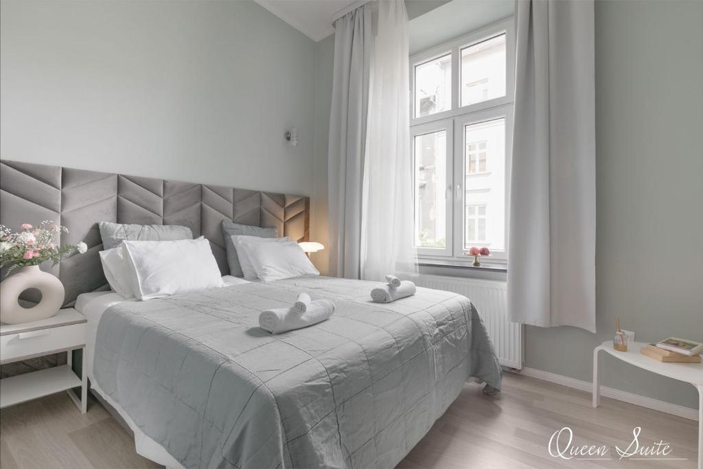 biała sypialnia z dużym łóżkiem i 2 ręcznikami w obiekcie Platinum Suites w Krakowie