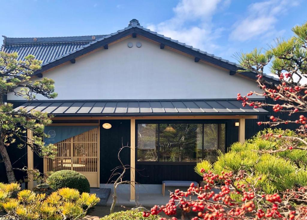 a house with a black and white facade at shukubo michiru 満行寺 in Hagi