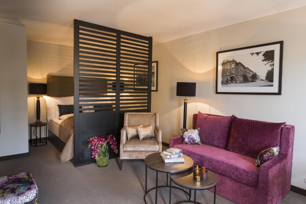 a living room with a purple couch and a bed at Saga Apartments Oslo in Oslo