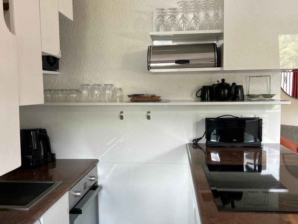 a kitchen with white cabinets and a microwave at Appartement Les Gets, 3 pièces, 4 personnes - FR-1-623-292 in Les Gets