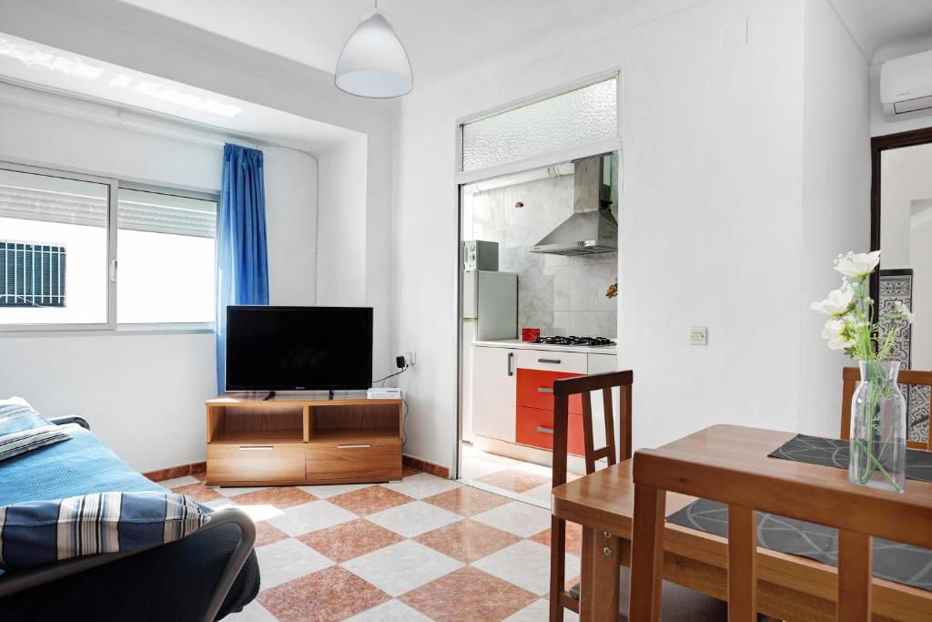 een woonkamer met een tv en een eettafel bij Casa Colomera 1 in Barbate