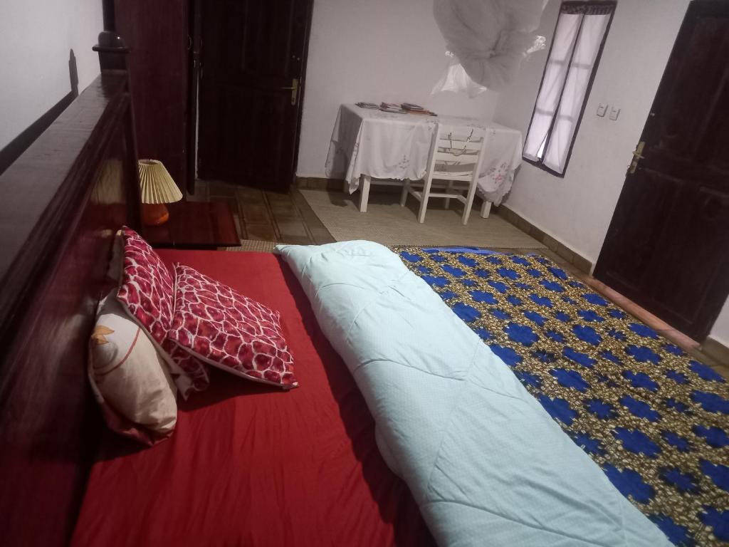 a large bed in a room with a table at Rwanda African Art Museum in Nyabisindu