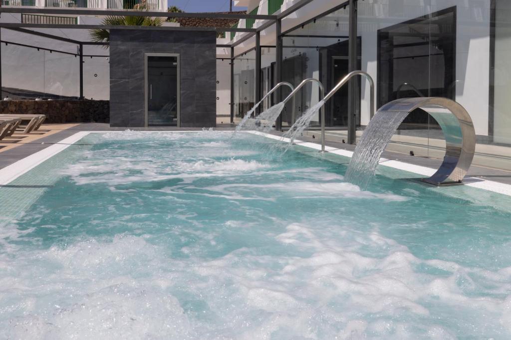 a swimming pool with a water slide in a building at MYND Yaiza in Playa Blanca