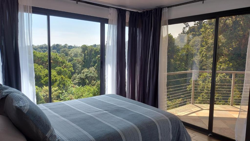 a bedroom with a bed in front of a large window at Casa de montaña Arisa in Cartago