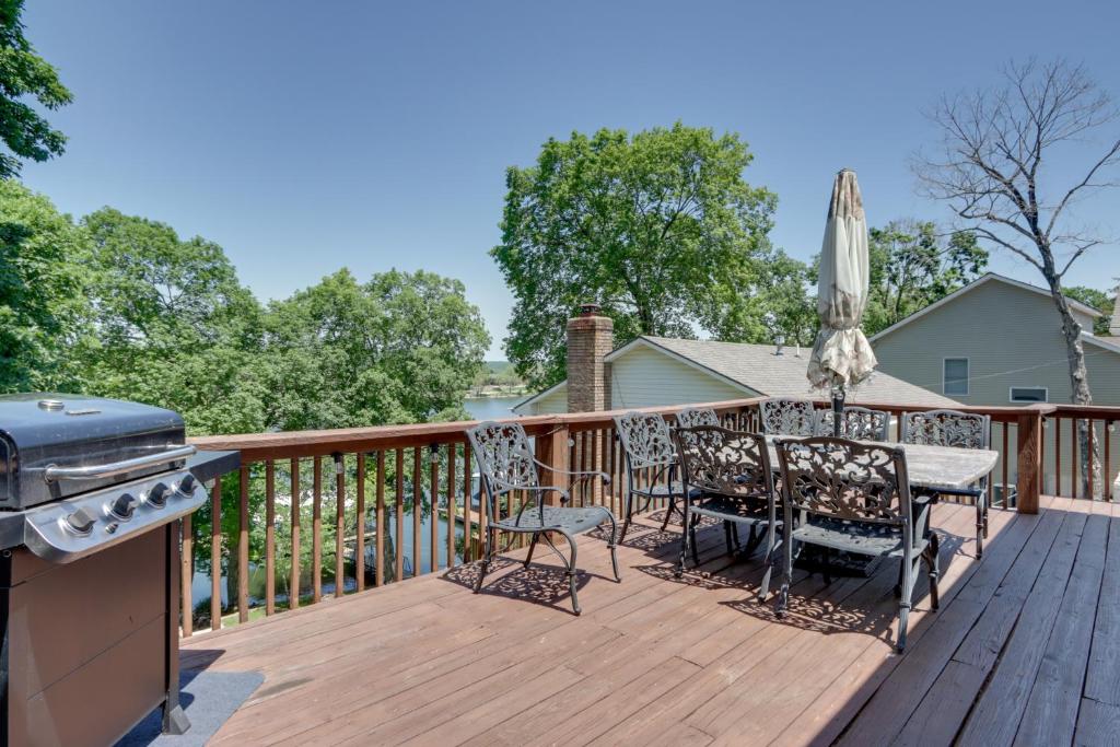 a deck with a grill and a table and chairs at Lakefront Missouri Vacation Rental with Dock and Slip! in Camdenton