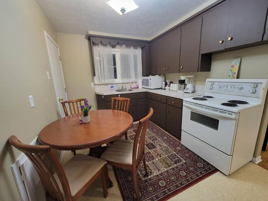 a kitchen with a table and a white stove top oven at Cozy apt in center of Saint John NB in Saint John
