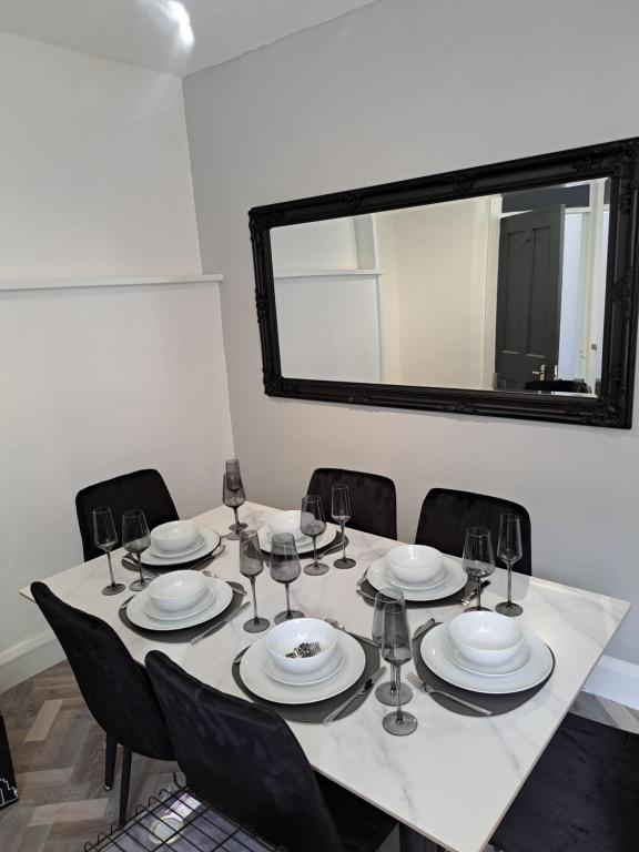 a dining room table with chairs and a large mirror at Manse Apartment in Great Malvern
