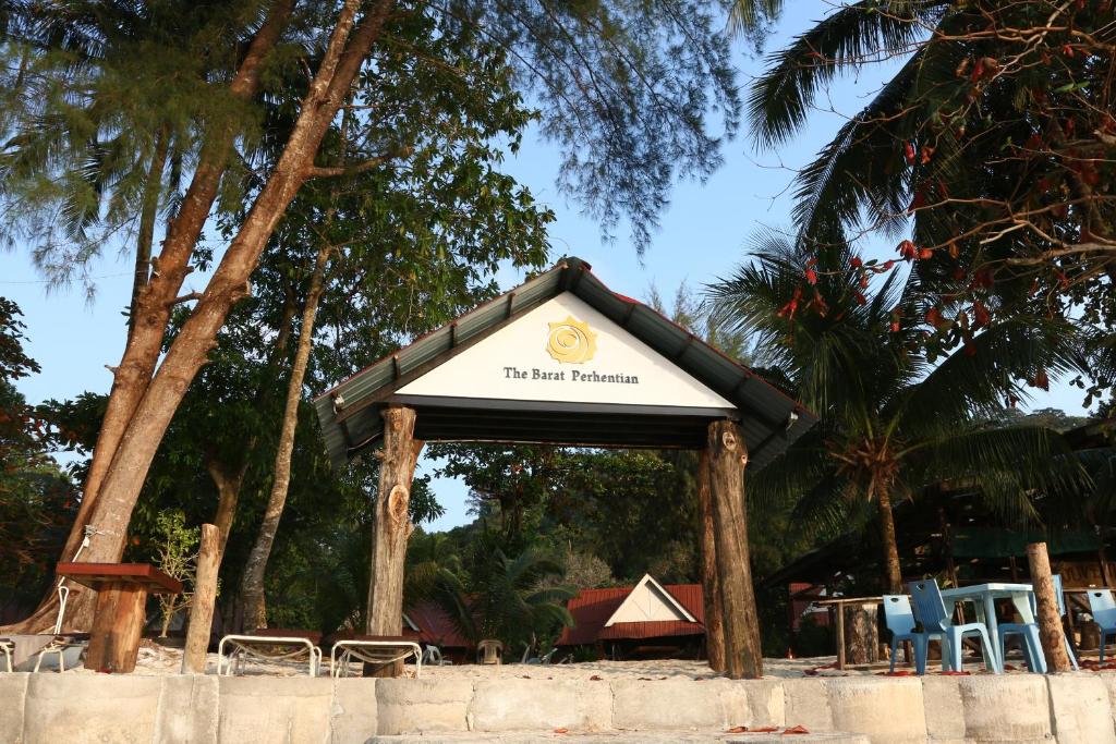 un letrero para un complejo con sillas y árboles en The Barat Perhentian, en Islas Perhentian