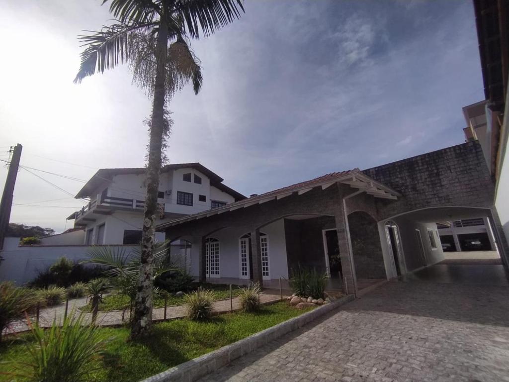 una casa con una palmera delante de ella en Bom Sossego, en Joinville