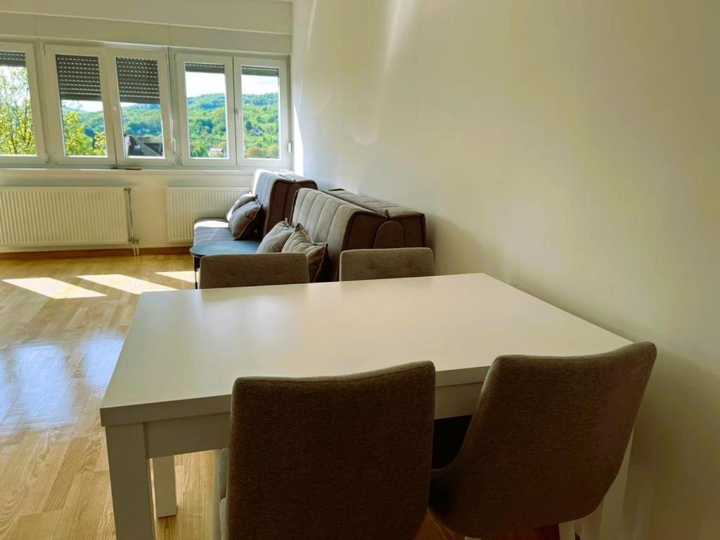 ein Wohnzimmer mit einem Tisch und Stühlen in der Unterkunft Apartment River in Bratunac