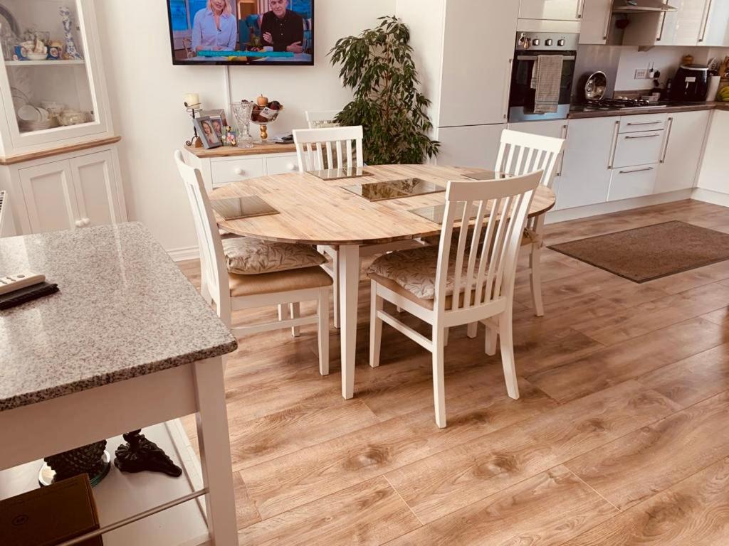 a kitchen with a wooden table and chairs at Home from home - Free Parking (near Edinburgh / Airport and Ingilston) in Edinburgh