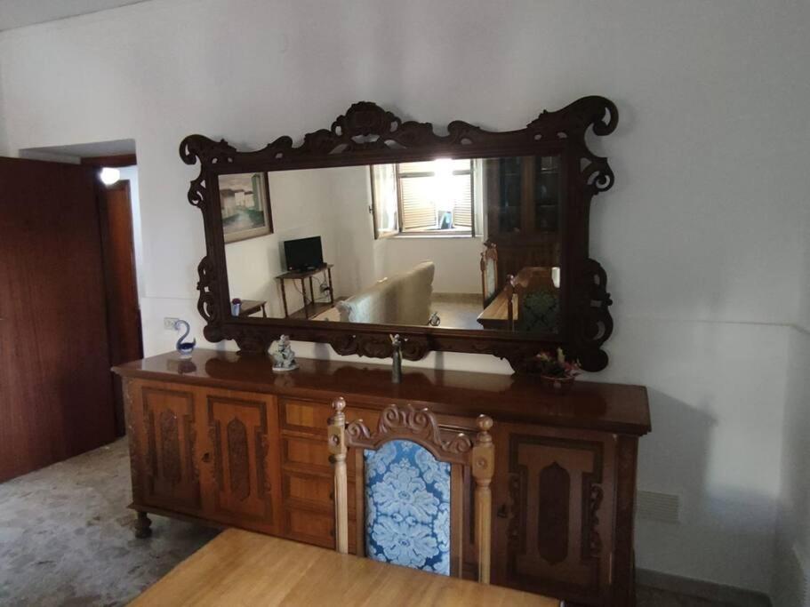 a large mirror on top of a wooden dresser at Appartamento a 50mt dal mare in Amantea