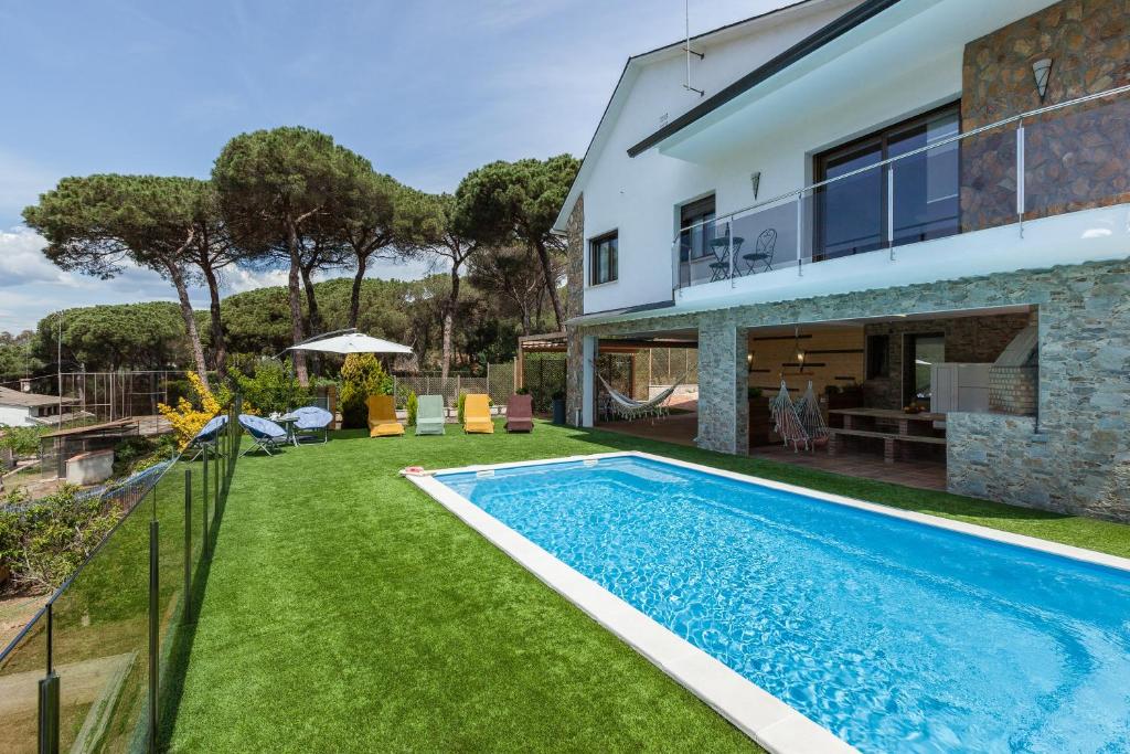 un patio trasero con piscina y una casa en Armonia completa, en Llinars del Vallès