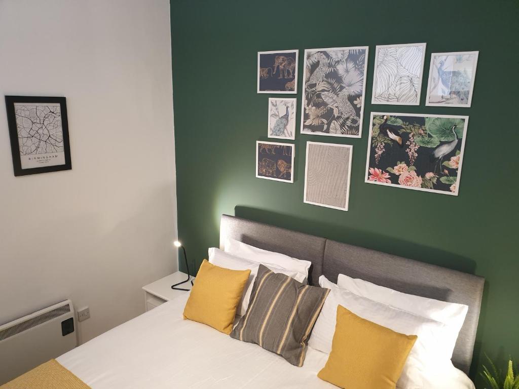 a bedroom with a green wall and a bed with pillows at Platinum Apartment Birmingham- Free Secure Parking- Fast Fibre Wi-Fi in Birmingham
