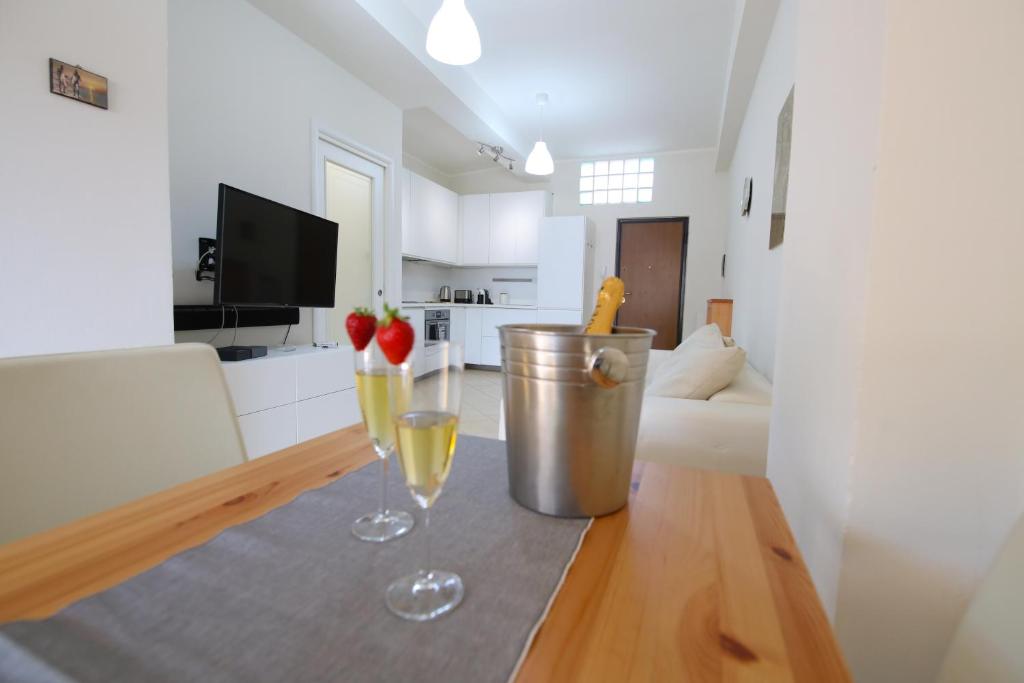 una cucina e un soggiorno con due bicchieri da vino su un tavolo di Costabella Apartment Tropea a Tropea