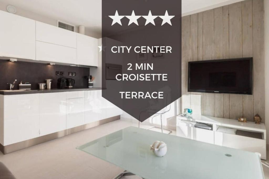 une cuisine avec des armoires blanches et un grand panneau sur le mur dans l'établissement Downtown Cannes Modern 1-Br Apartment, à Cannes