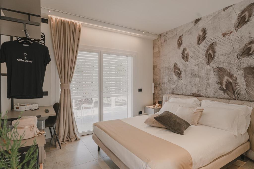 una camera con letto e parete con piume di VillaLume a Marina di Castagneto Carducci