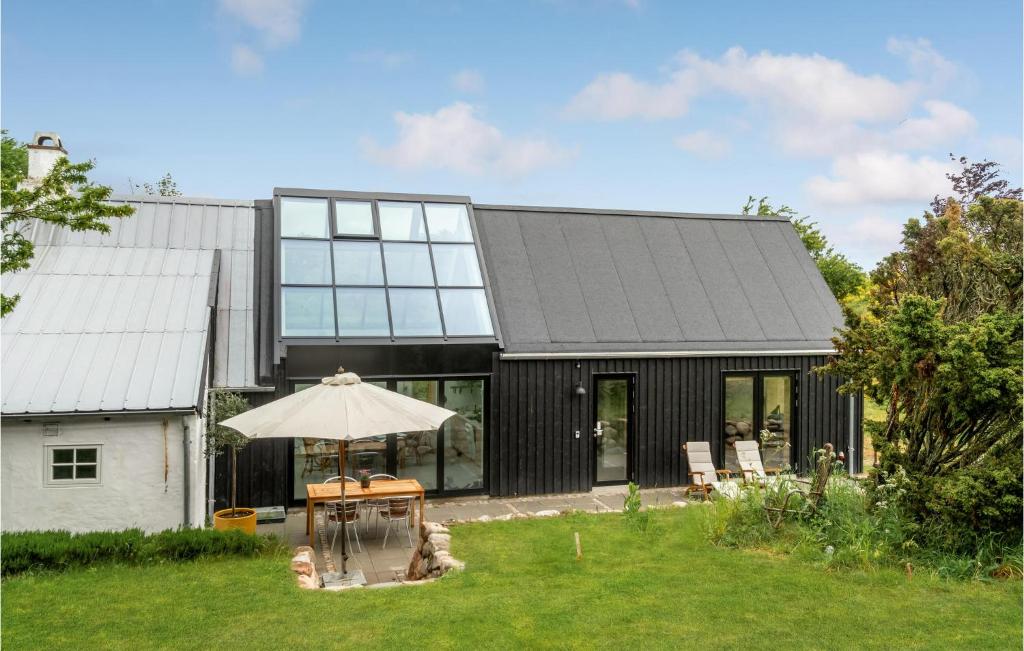 a black house with a table and an umbrella at Stunning Home In Knebel With House A Panoramic View in Knebel