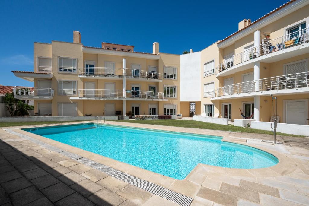 an apartment with a swimming pool in front of a building at The Flat in Ericeira