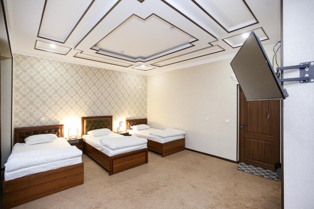 Cette chambre comprend deux lits et une lucarne. dans l'établissement Hotel DREAM PLAZA, à Boukhara