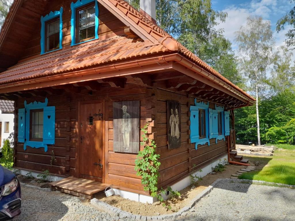 a log cabin with blue windows and a roof at Tajojta in Werlas