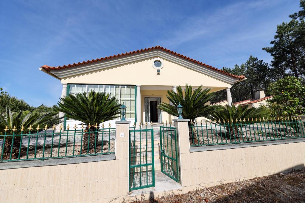 uma casa com um portão e palmeiras em Nazaré Landscape em Nazaré