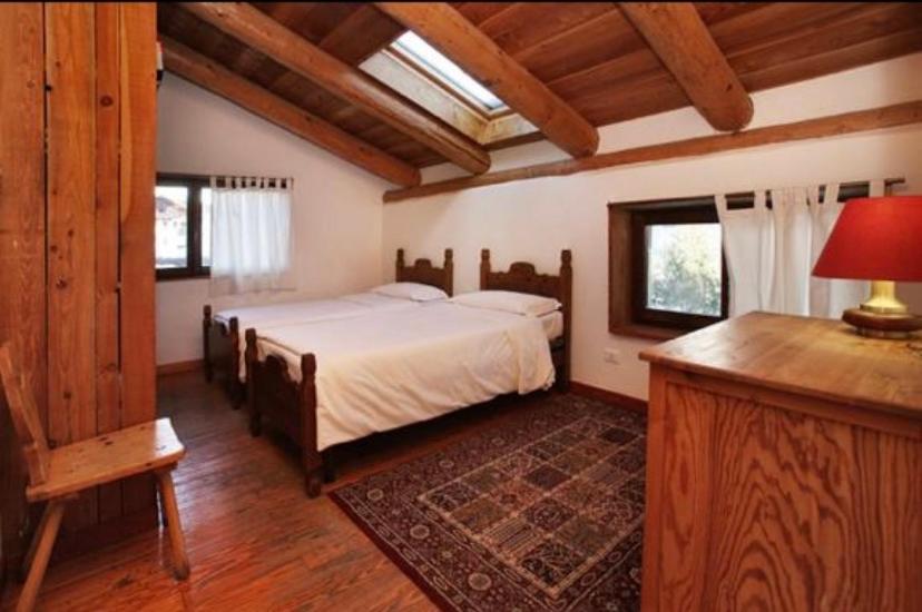 a bedroom with a bed in a room with wooden ceilings at Hotel Derby Bar in Sauze dʼOulx