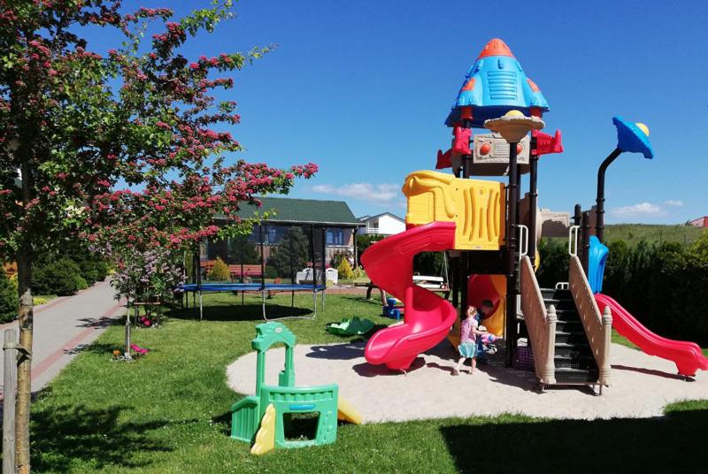 a child playing on a playground with a slide at Domki Kazimierz in Darłowo