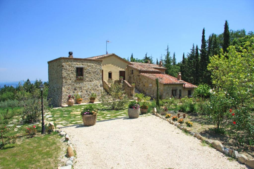 a stone house with a driveway in front of it at Villa la felce in Cetona