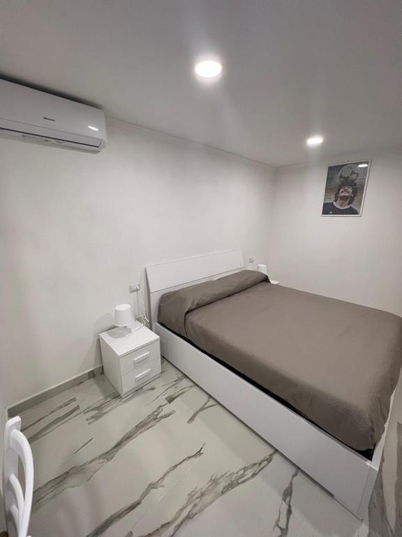 een kleine slaapkamer met een bed en een nachtkastje bij Sciabbacco house in Napels