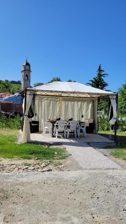 ein Zelt mit einem Tisch und Bänken auf einem Feld in der Unterkunft Casa vacanze in Mombarcaro